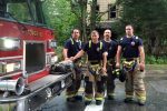 Image of firefighters posing by firetruck Thumbnail