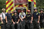 7 firefighters posing in front of firetruck Thumbnail