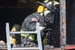 Firefighter spraying burned building Thumbnail